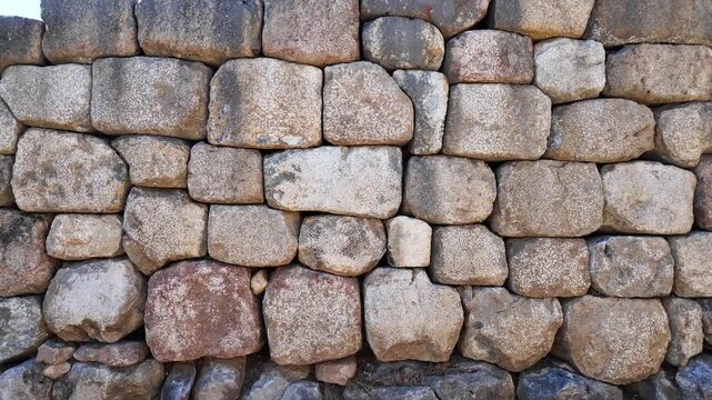 Massive cyclopean stone masonry wall section built with fitted ancient boulders at the Hattusa archaeological site in Turkey.