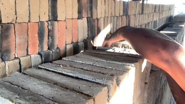 Worker Arranging Raw Bricks Before Firing in a Traditional Brick Kiln