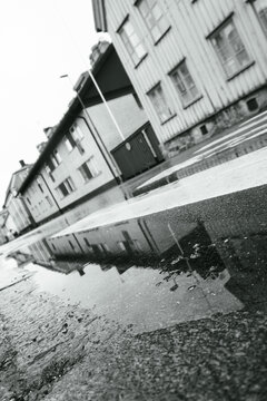 Monochrome reflection of wooden houses in puddle