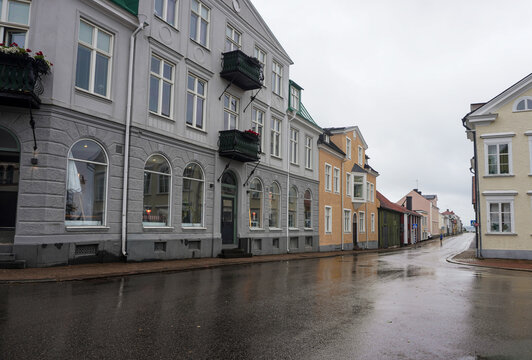 Wet city street flanked by historic buildings