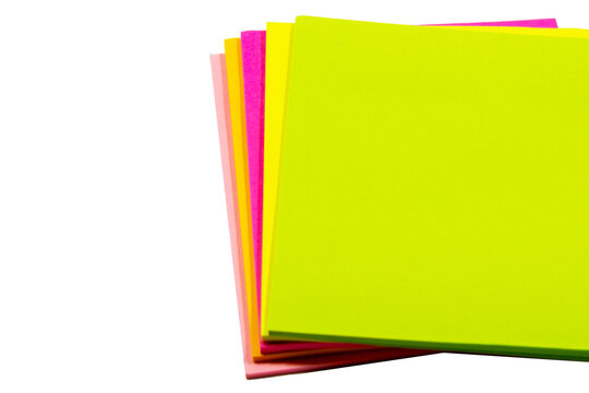 A stack of square, neon-colored adhesive paper notes, arranged in a fanned-out pattern against a plain white background