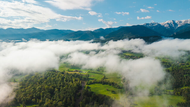 Panoramic aerial landscape of foggy Pyrenees mountains and green valleys in Catalonia Spain with floating clouds over forests and rural countryside