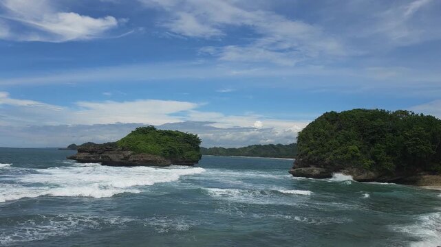 Scenic ocean waves crashing between tropical rocky islands, Tanjung Penyu Beach, Malang, Indonesia