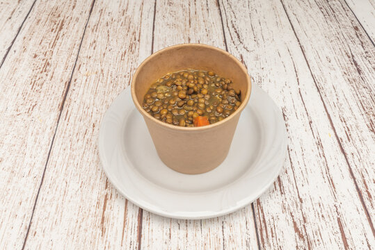 Braised Lentil Stew with Carrots Served in Kraft Paper Cup on White Plate