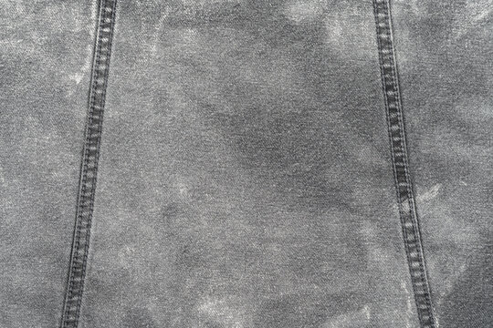 Closeup of faded denim fabric with double stitching
