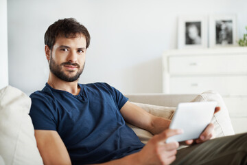 Obraz premium Tablet, smile and portrait of man on sofa in home for streaming service, movie search and media app. Online film platform, subscription and chill with person in house for connection and entertainment