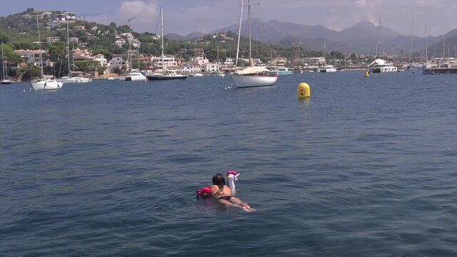 Woman relaxing on unicorn inflatable ring in open Mediterranean Sea