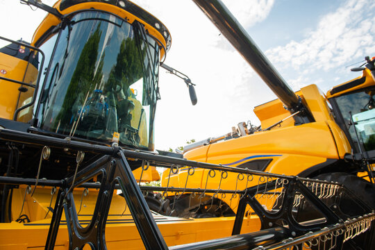 Modern yellow combine harvester with corn header, close-up agricultural machinery