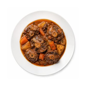 Spanischer Rabo de Toro, langsam geschmorter Ochsenschwanz mit Kartoffeln und Karotten in kr&auml;ftiger Sauce, auf wei&szlig;em Teller serviert und von oben freigestellt fotografiert.