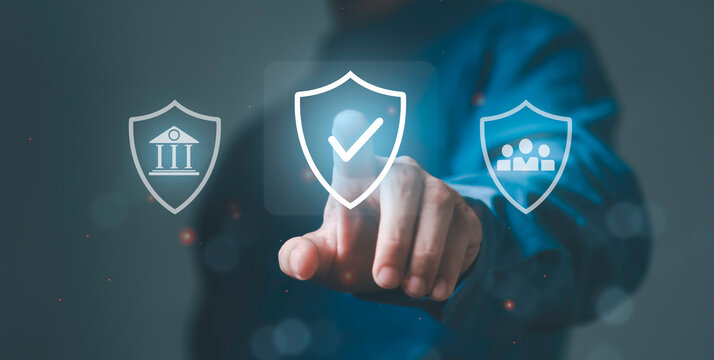 Businessman hand touching digital shield icons for banking, secure verification and human resources. Data protection, corporate security and integrated system trust.