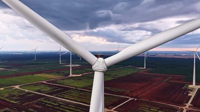 Aerial view of wind turbines in the Kaigu purvs peat bog landscape under a dramatic cloudy sky in Livberze parish, Jelgava Municipality, Latvia.