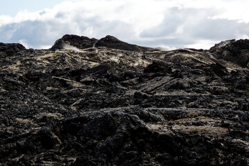Obraz premium Steaming Lava Field Under Cloudy Sky