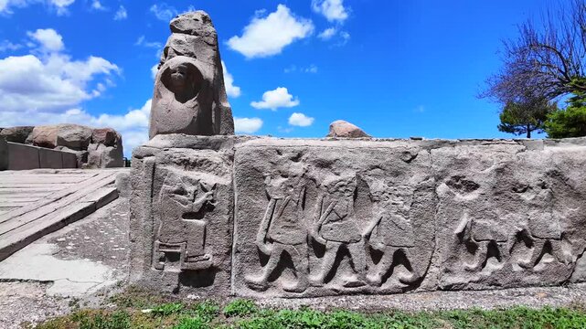 Ancient Hittite bas-relief carvings depict musicians, acrobats, and figures carved into stone blocks at Alacah&ouml;y&uuml;k archaeological site in Turkey.