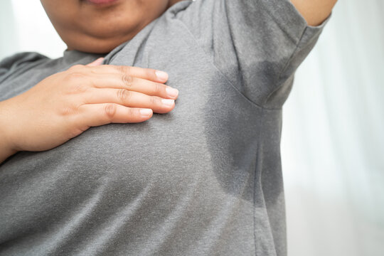 Sweaty underarms, Asian woman with sweat on clothes under armpit.