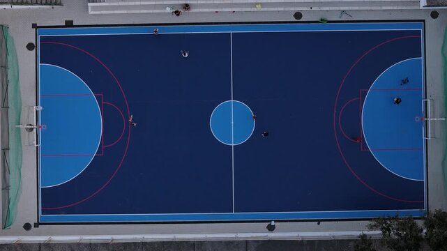 Aerial view of a blue and dark blue sports court with people playing in Cascais, Portugal.