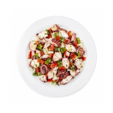 Ensalada de Pulpo mit Oktopus, roter und gr&uuml;ner Paprika, Zwiebeln und Kr&auml;utern, frisch auf wei&szlig;em Teller serviert und freigestellt aus der Vogelperspektive fotografiert.