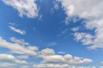 Obraz premium Cloudscape with white fluffy clouds in sunset sky