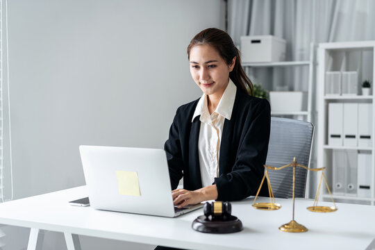 Legal professional woman works laptop office desk justice scales gavel law firm attorney consultation business administration professional environment