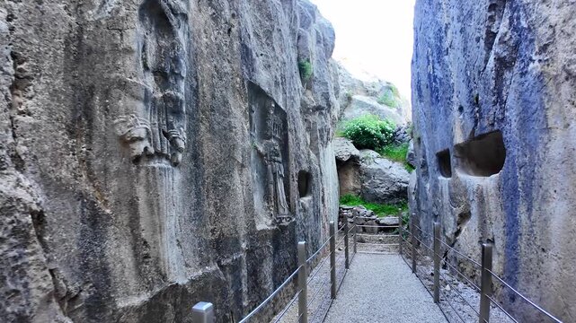A detailed rock relief carving depicts King Tudhaliya IV under the protection of God Sharruma inside Yazılıkaya&rsquo;s rock sanctuary.