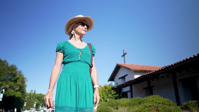 Happy woman walks around historic Mission church San Francisco Solano de Sonoma in California while enjoying the sunshine