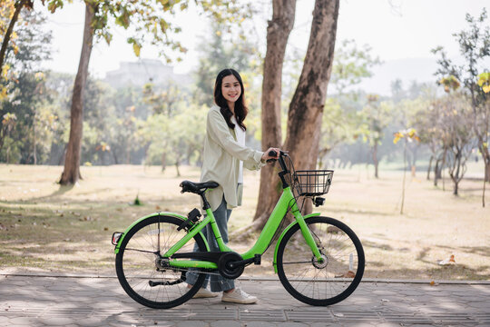 A woman is standing next to a green bicycle
