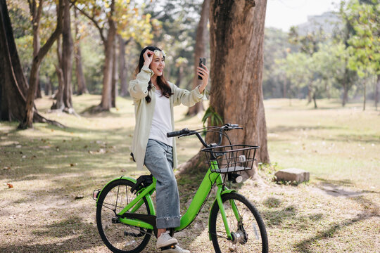 A woman is riding a green bicycle in a park