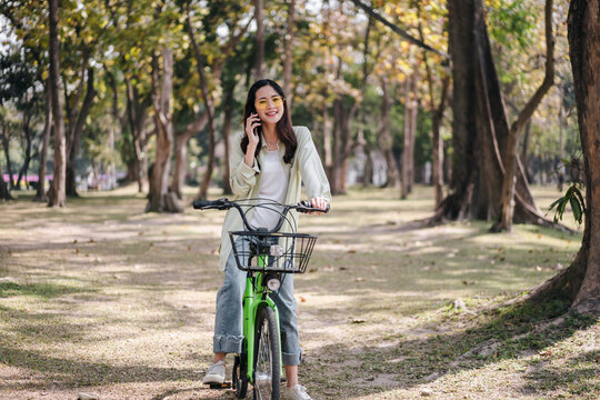A woman is riding a green bicycle in a park