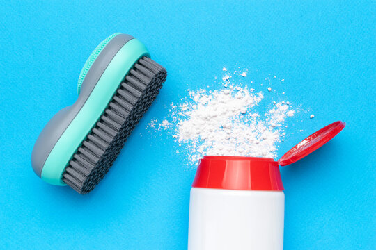 Cleaning Essentials: Scrub Brush and Powder on Vibrant Blue Background