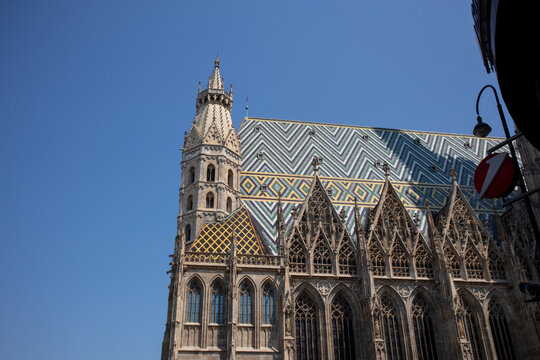 Dettaglio della Cattedrale di Santo Stefano a Vienna con il caratteristico tetto in tegole smaltate a motivi geometrici colorati e la torre gotica sotto un cielo blu
