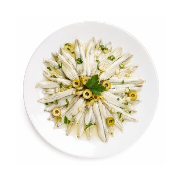Boquerones en Vinagre, marinierte spanische Sardellen mit Oliven, Knoblauch, Petersilie und Oliven&ouml;l, dekorativ auf wei&szlig;em Teller angerichtet und von oben fotografiert.