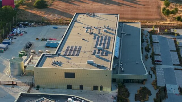 Aerial view of the Moderna Innovation and Technology Center featuring solar panels on the roof and surrounding industrial infrastructure in Harwell Oxford, England, United Kingdom.