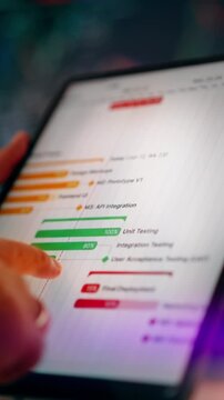 IT project roadmap software development lifecycle progress digital tablet screen displaying project timeline and milestones. Close up view of a hand touching the screen of a modern tablet