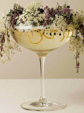 Sparkling botanical drink with flowers in glass goblet