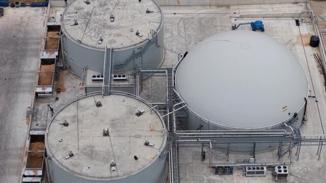 Aerial view of the Moor Bio Energy anaerobic digestion plant featuring large industrial storage tanks and complex piping infrastructure in Grantham, England, United Kingdom.