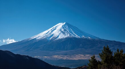 Fototapeta premium Majestic snow capped Mount Fuji against a clear blue sky. Travel and nature concept for tourism and vacation.