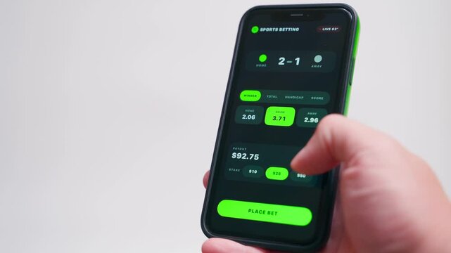 Hand holding smartphone showing sports betting app with live odds close-up 