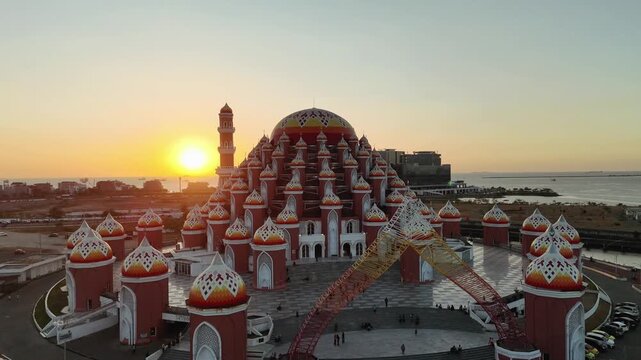 Aerial view of Masjid Kubah 99 Asmaul Husna at sunset with its distinctive colorful domes and waterfront setting in Makassar, Sulawesi Selatan, Indonesia.