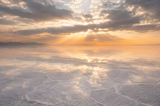 Golden Sun Rays Over Endless Salt Flats with Reflective White Crystal Surface