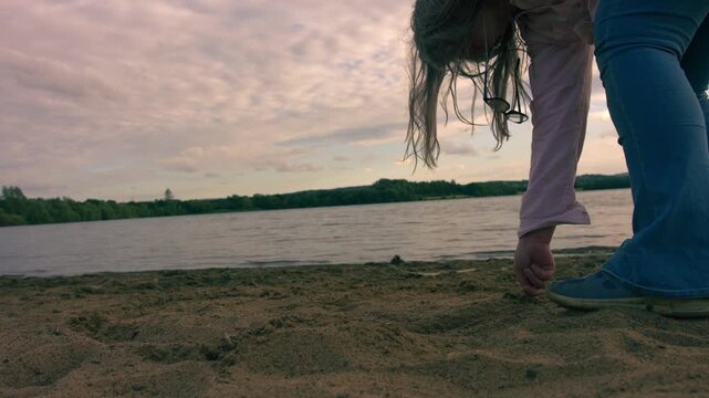 Woman drawing a line in the sand at beach