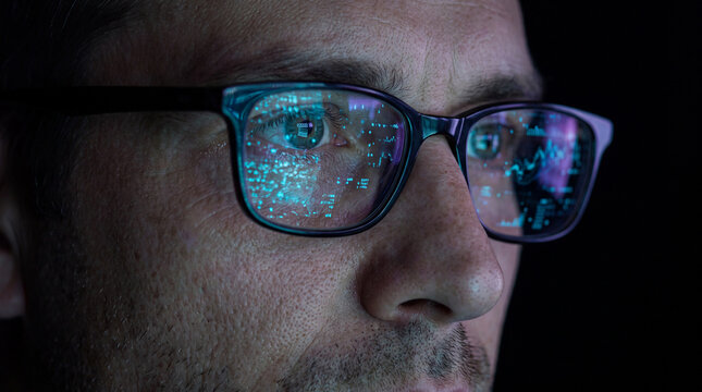 Close-up of a man's eyes reflecting financial market data