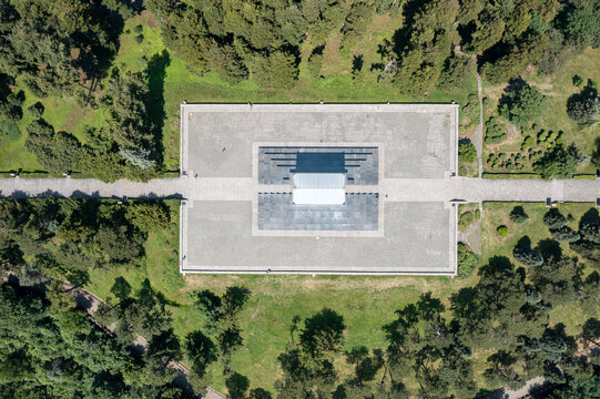 Aerial view of the Monument to the Unknown Hero on Mount Avala, surrounded by lush green forest and stone pathways in Belgrade, Serbia.