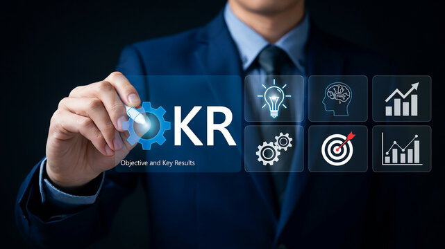 Businessman touching screen displaying KR Objective and Key Results icons for business strategy and goal setting