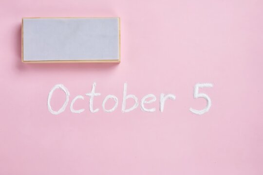 October 5 calendar date written on pink background, autumn schedule concept, minimalist pink flat lay with blank marble sign