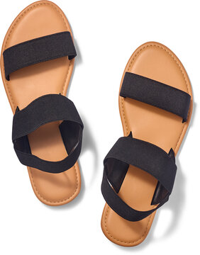 pair of women sandals isolated white background, black elastic straps and tan brown flat soles, summer footwear fashion in top view