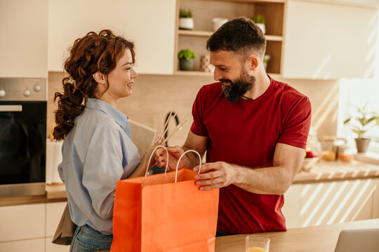 Couple bringing take-out food into kitchen