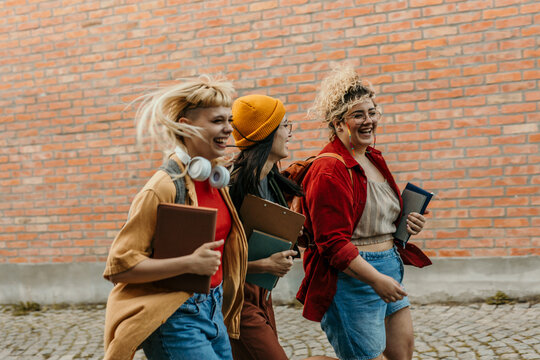 Diverse students laughing and running on college campus