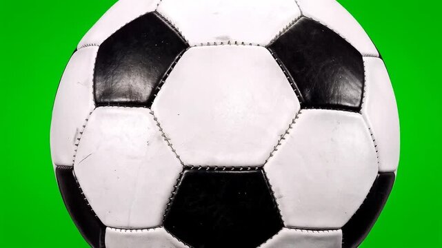 Single black and white soccer ball isolated spinning on green screen HD video for video editing