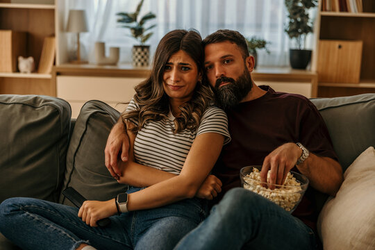 Couple watching scary movie at home feeling fear