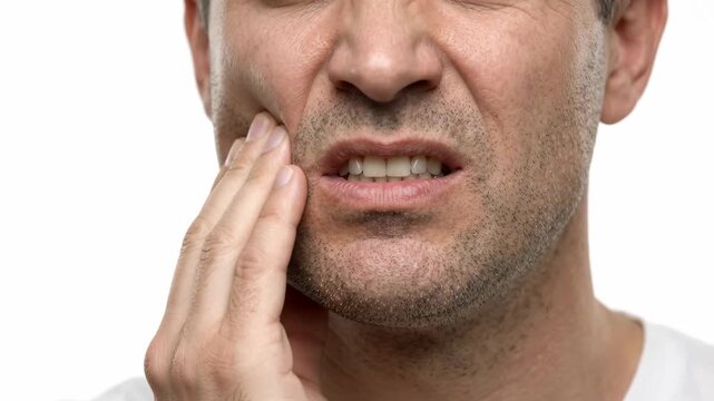 Man touching his cheek in pain from a severe toothache