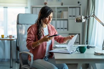 Woman scanning document using smartphone working from home